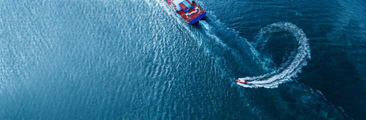 Pilot boat turn behind stern of Vessel Cargo container Ship in the ocean sea concept logistic...