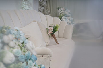 beautiful flowers on a chair. White and fresh flower bouquet. bridal bouquet with colorful flowers, hydrangeas, roses. Detail of beautiful pink carnation bouquet on white chair background.