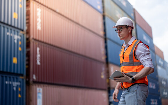 Container operator holding a tablet to do his routine inspection while working in container yards.