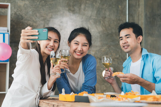Group of young Asians having fun taking pictures at company parties, startup parties, new year parties, annual company parties, alcoholic beverages. Company employee party catering ideas, celebrations