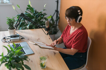 Middle-aged woman radio host making podcast recording for online show - broadcast and dj concept