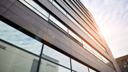 Glass and aluminum facade of a modern office building. View of futuristic architecture. Office building with cloud reflection on windows