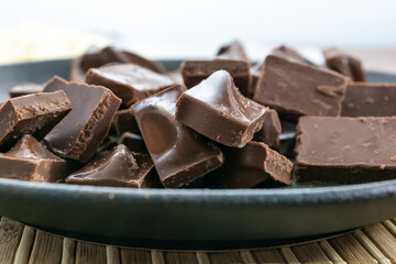 close up shot of milk chocolate pieces on a dark plate
