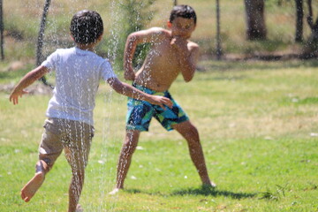 Children playing with water on hot summer day