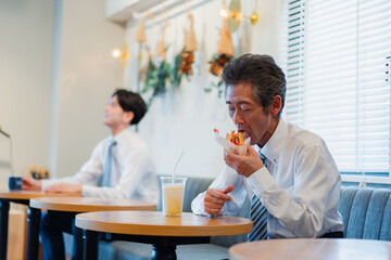 ハンバーガーショップでランチを食べるビジネスマン