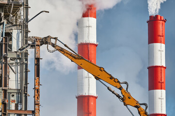 Hydraulic cutter destroys old building against chimneys