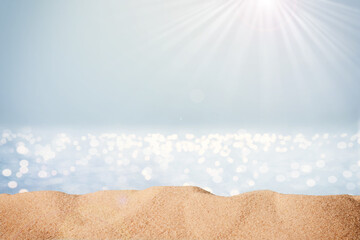 Blurred sea background with sand and sunlight. Backdrop for advertising summer travel and sun...