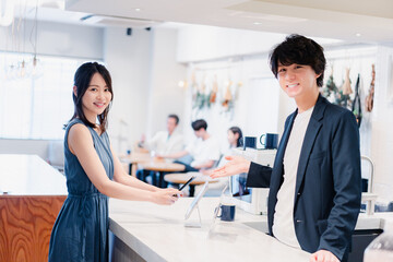 Obraz premium スマホ決済をする若い女性