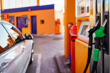 Car parked at a gas station, ready to refuel from the hoses.