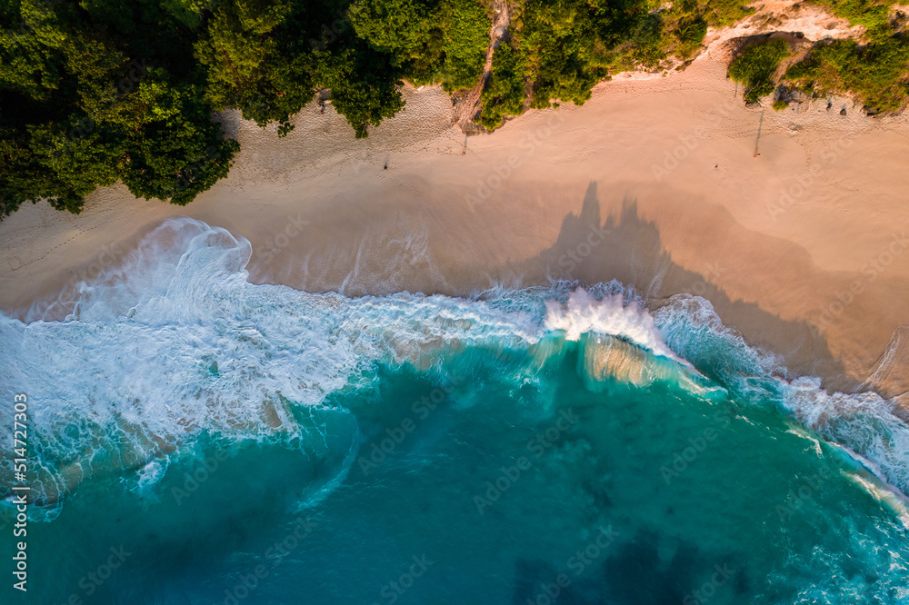 Wall mural Aerial drone top view shot of rocky beach with cliff. Indian ocean shore. Copy space for text. Nature and travel background. Beautiful natural summer vacation travel concept. Waves and sand. - Wall murals