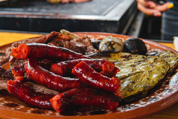 Traditional dish filled with sausage, a nopal and meat on a spit. High quality photo. Background butchery. Dish being prepared.