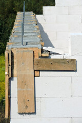 A reinforced concrete beam and a wooden formwork on the first floor of a house under construction, walls made of autoclaved aerated concrete