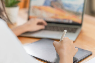 Lifestyle and technology concept, Young Asian woman writing on tablet and using laptop to working.