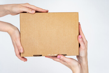 Box in caring female hands. Concept of packaging for goods. Order from online store in cardboard...