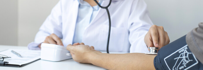 Female doctors use blood pressure monitors and stethoscope to measure pulse Diagnose the patient's...