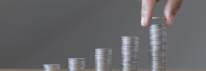 Man's hands put the coins arranged in steps, Managing your finances or saving money for future use,...