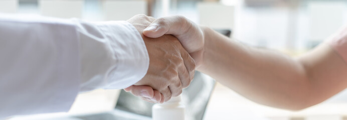 Two men holding hands, Asian doctor smiled shake hands with the patient congratulating him on being healthy and strong, Successful treatment, Hold hands, Handshake, shook hands.