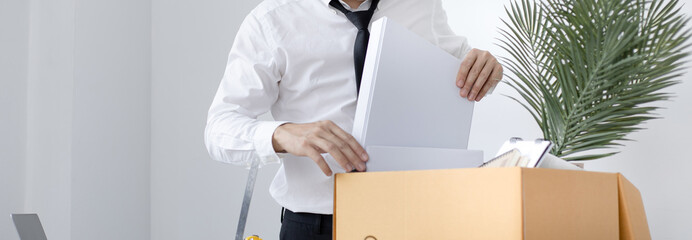 Put the work equipment in the office in a large brown box, Businessmen are keeping work documents...