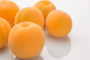 Yellow ripe apricots on a white background