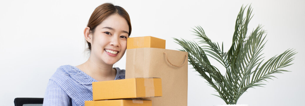 Young woman embraced a mailbox and a brown paper bag in preparation for the delivery of her order, New business style for young people working at home and owning businesses, Sell online concept.