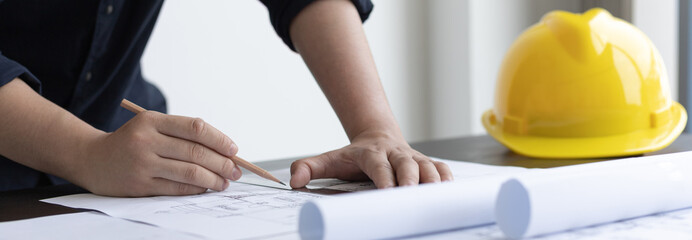 Architectural building design and construction plans with blueprints, Young man was designing a...