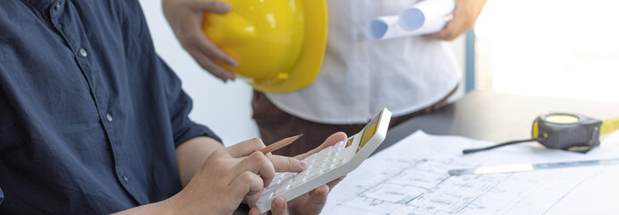 Meeting of engineers and architects in building planning, Consulting and brainstorming experts in architectural planning using blueprints, tape measure, rulers, laptop in designing buildings.