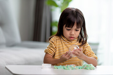Kid play with handgum. Slime in children hands.