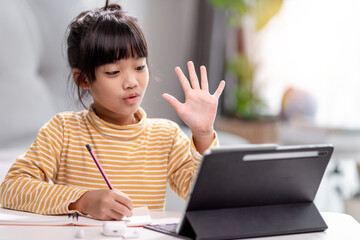 Asian girl students in online learning classes study online with Tablet at home.