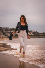 Portrait of a blonde woman enjoying the beach walking barefoot by the sea