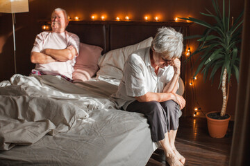 Sad seniors couple in bed at home - Powered by Adobe