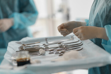 Surgical instruments and tools including scalpels forceps and tweezers arranged on table for surgery