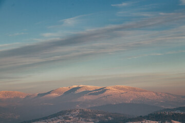 Perfectly frosty morning at the top of Ochodzita hill in the Polish Beskydy Mountains. A view of snow-covered hills and snow-covered trees in the morning sunlight