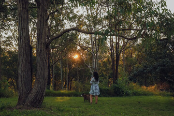 Naklejka premium Woman in beautiful forest setting with lovely American Bulldog