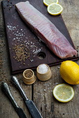 seared tuna fillet on a wooden board with lemons vertical photo