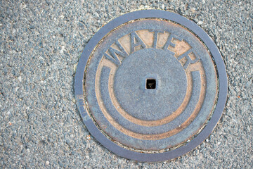 metal water street cover with textured pattern around it