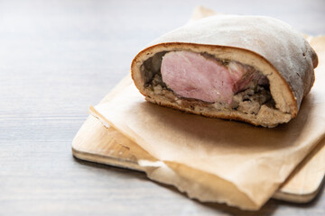 Schweinebraten im Brotteig auf Holztisch