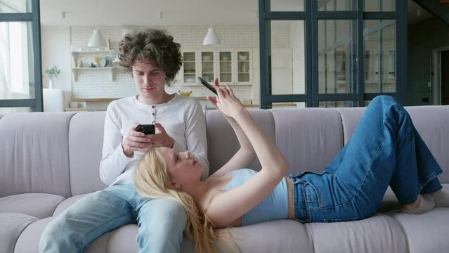 Couple of teens sitting back to back with their phones, social media addiction