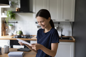 Cheerful happy student girl reading document, receiving letter from college, business school, bank...