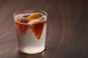 Grapefruit lemonade in tumbler glass on wood table