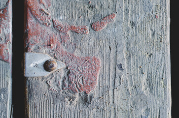 Dirty old floorboard. An aluminum tag with the number 6 nailed to the board. Stain of brown dried paint on the wooden surface. Gaps in the floor between the boards. Top view.
