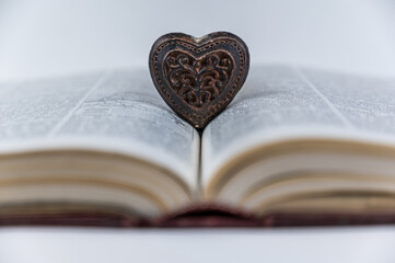 Wooden heart-shaped figurine. Large open book. Encyclopedia in red hardcover. Brown amulet with...