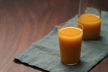 Fresh organic orange juice in tumbler glass on wood table