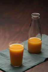 Fresh organic orange juice in tumbler glass on wood table