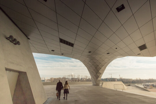 silhouette de deux personnes sous le mus&eacute;e des Confluences &agrave; Lyon, un b&acirc;timent d'architecture moderne et futuriste 