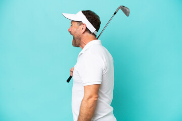 Middle age caucasian golfer player man isolated on blue background laughing in lateral position