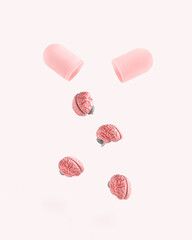 Pink pill with human brains on isolated pastel white background. Brainwashing and mind control idea. Minimal abstract concept of memory, psychology, brain fog, neurology, influence or manipulation.