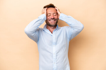 Middle age caucasian man isolated on beige background laughing