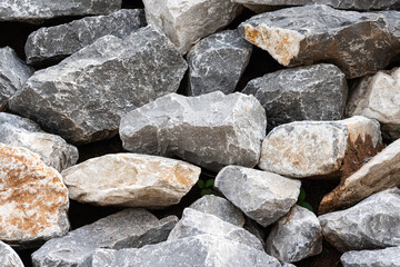 Pile of large piece pebble stones which are stacked up for barrier structure. Construction material and background textured.