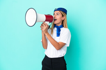 Airplane stewardess Uruguayan woman isolated on blue background shouting through a megaphone