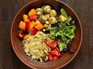 Salad with quinoa, sweet pepper, mushrooms, herbs and pistachios. Healthy nutrition. Vegetarian concept, top view, copy space